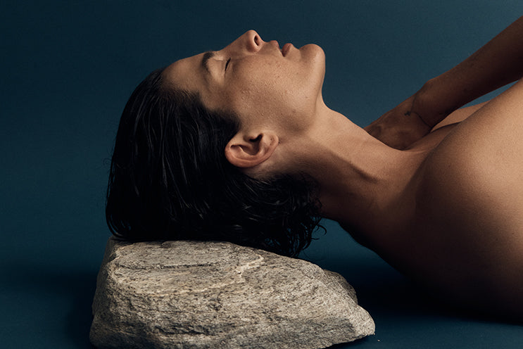 Woman resting her head on a rock